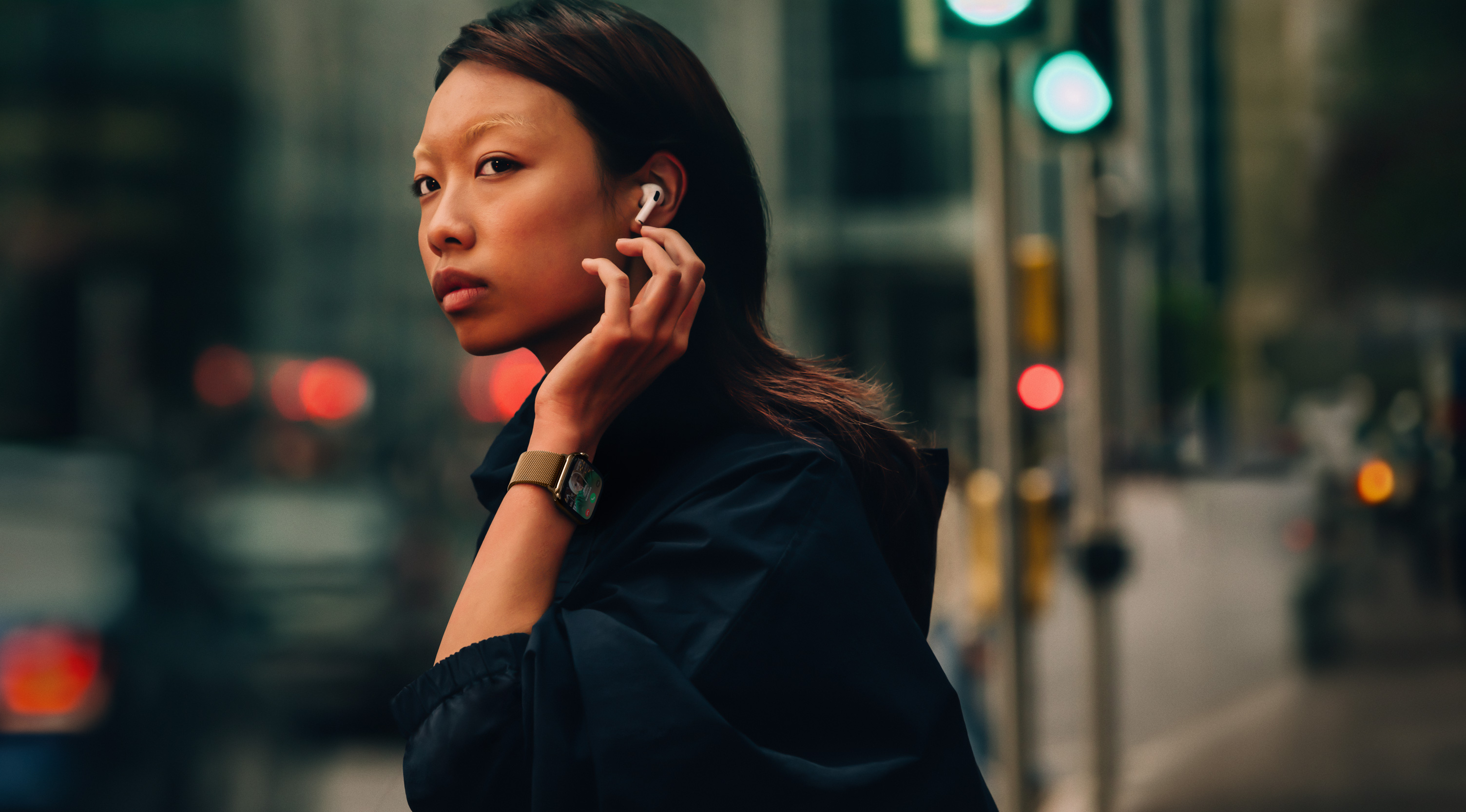 一位女士在街上，戴着 Apple Watch Series 10 和 AirPods。