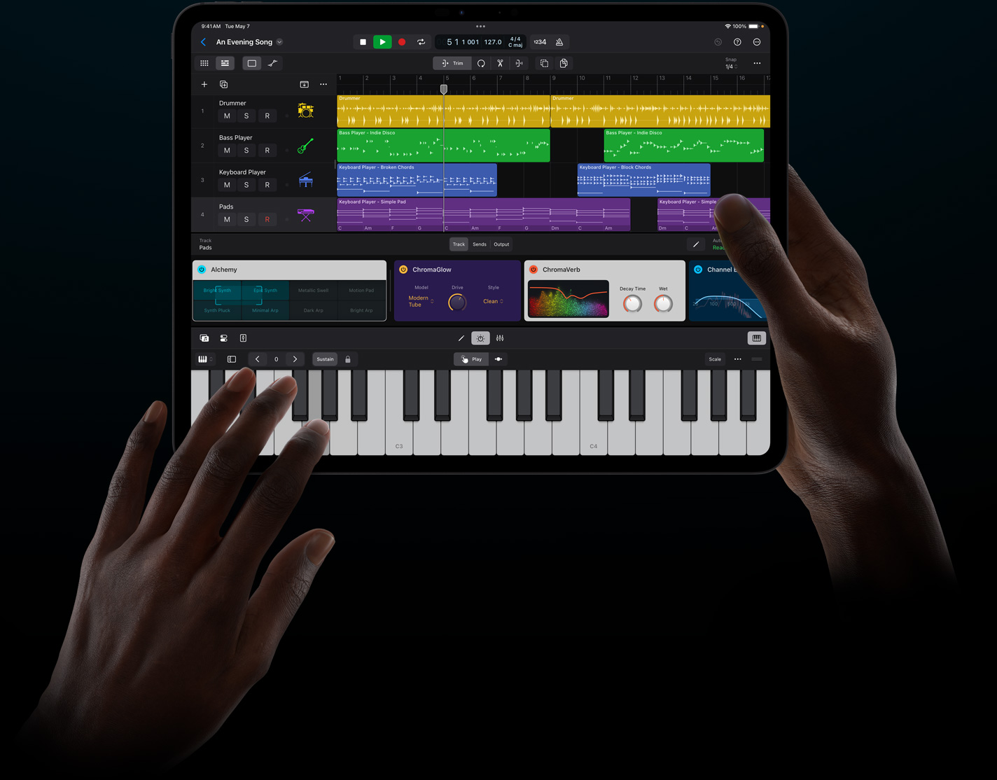 一双手拿着一部 iPad Pro，以触控方式在 iPad 版 Logic Pro 中演奏虚拟乐器。